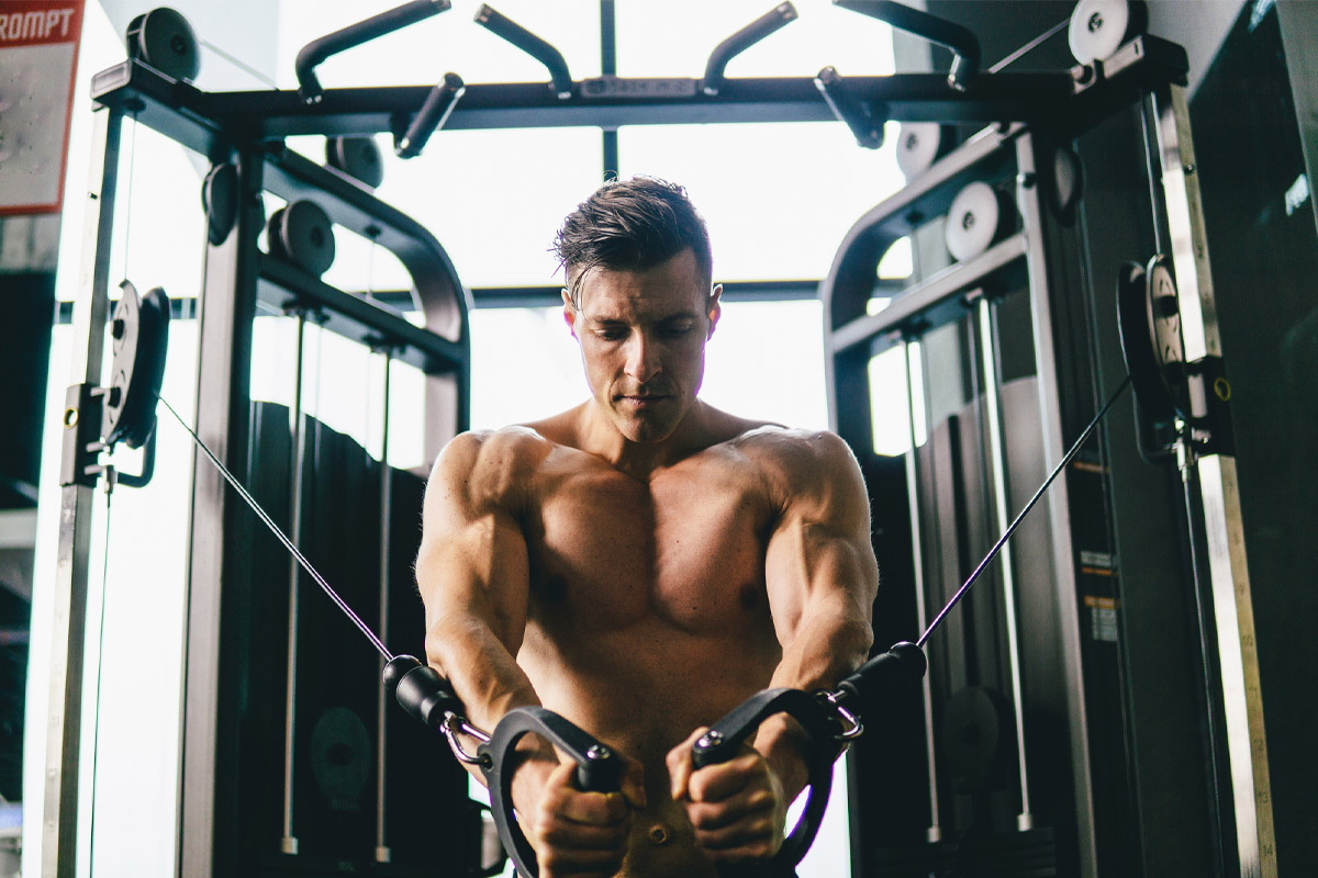 hombre entrenando pesas con una polea doble