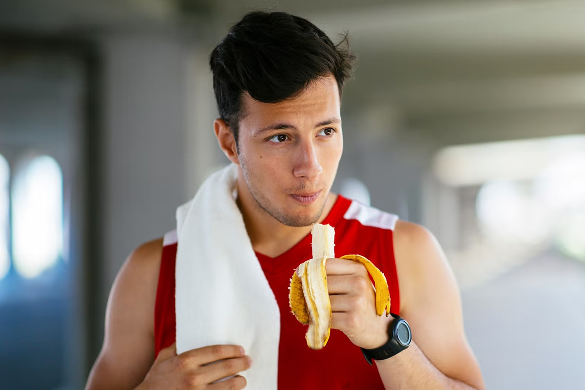 hombre comiendo un plátano después de entrenar