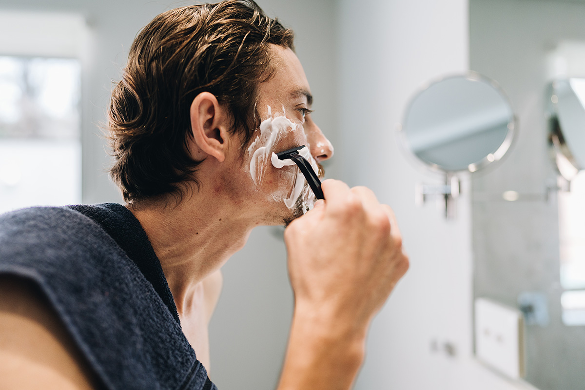 hombre rasurándose frente al espejo