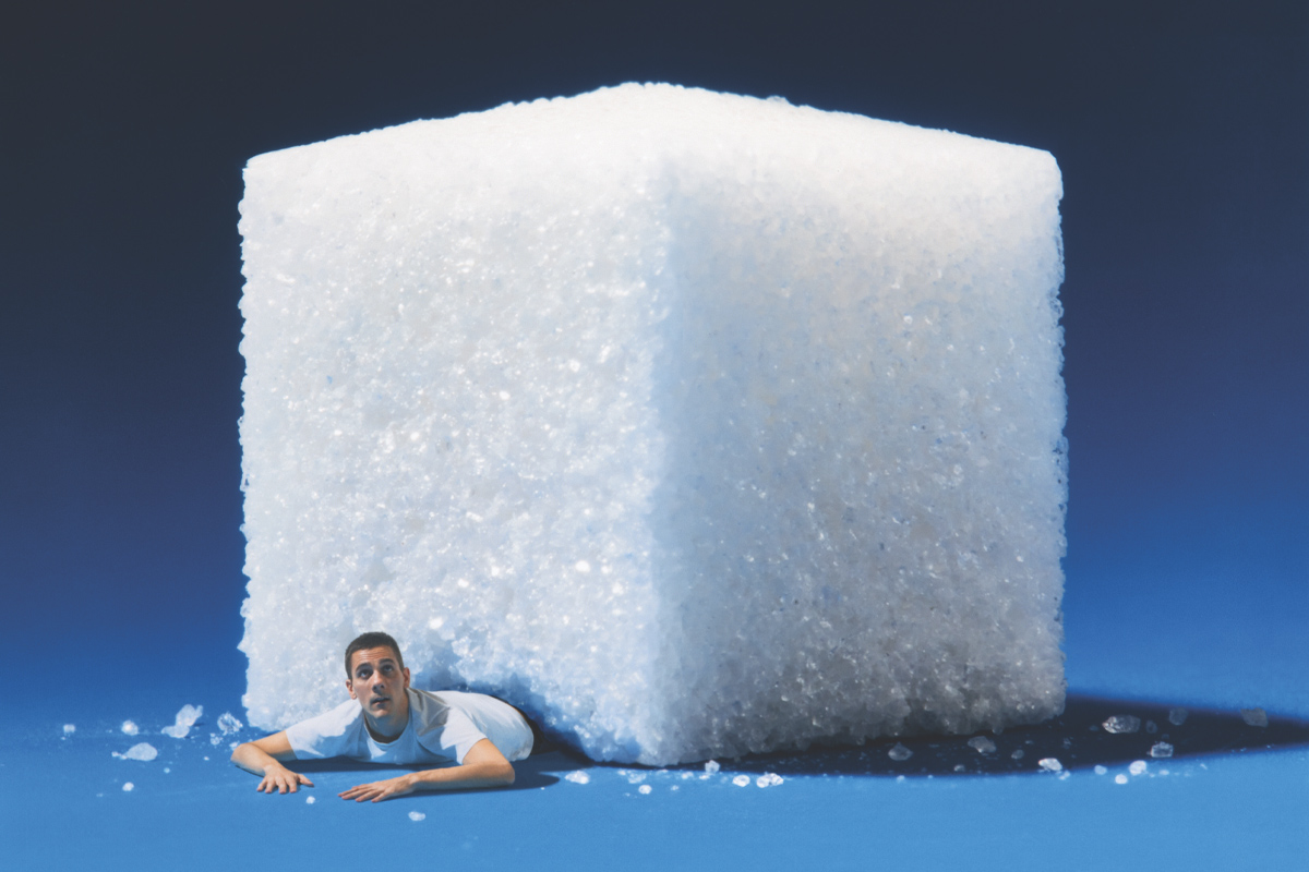 ilustración de hombre abajo de un terrón de azúcar gigante
