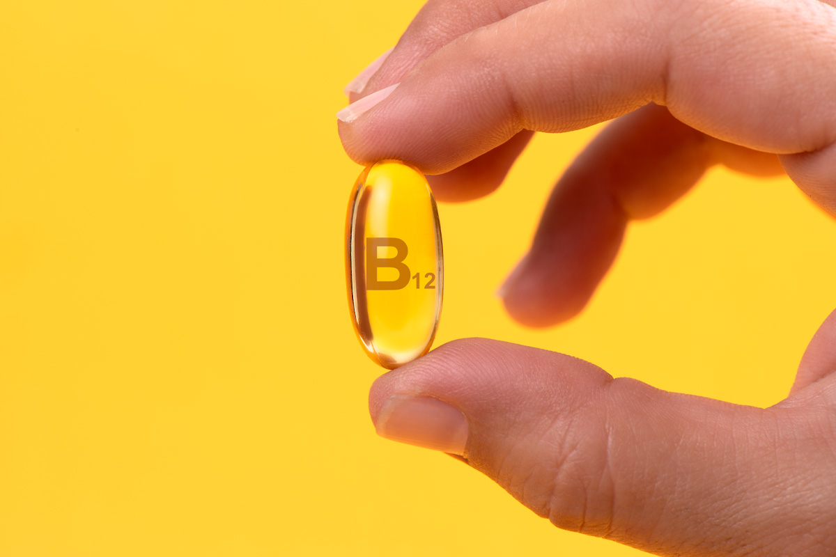 hombre sosteniendo una píldora de b12