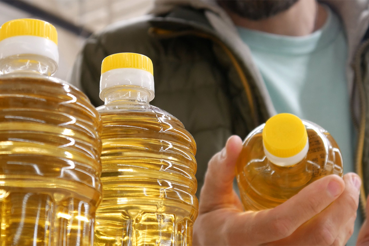 hombre viendo botella de aceite vegetal