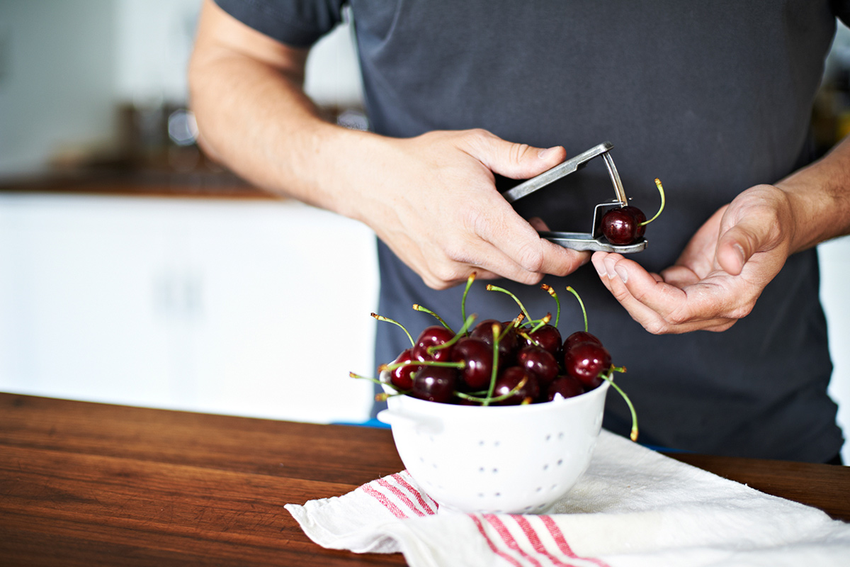 hombre quitando hueso a cerezas