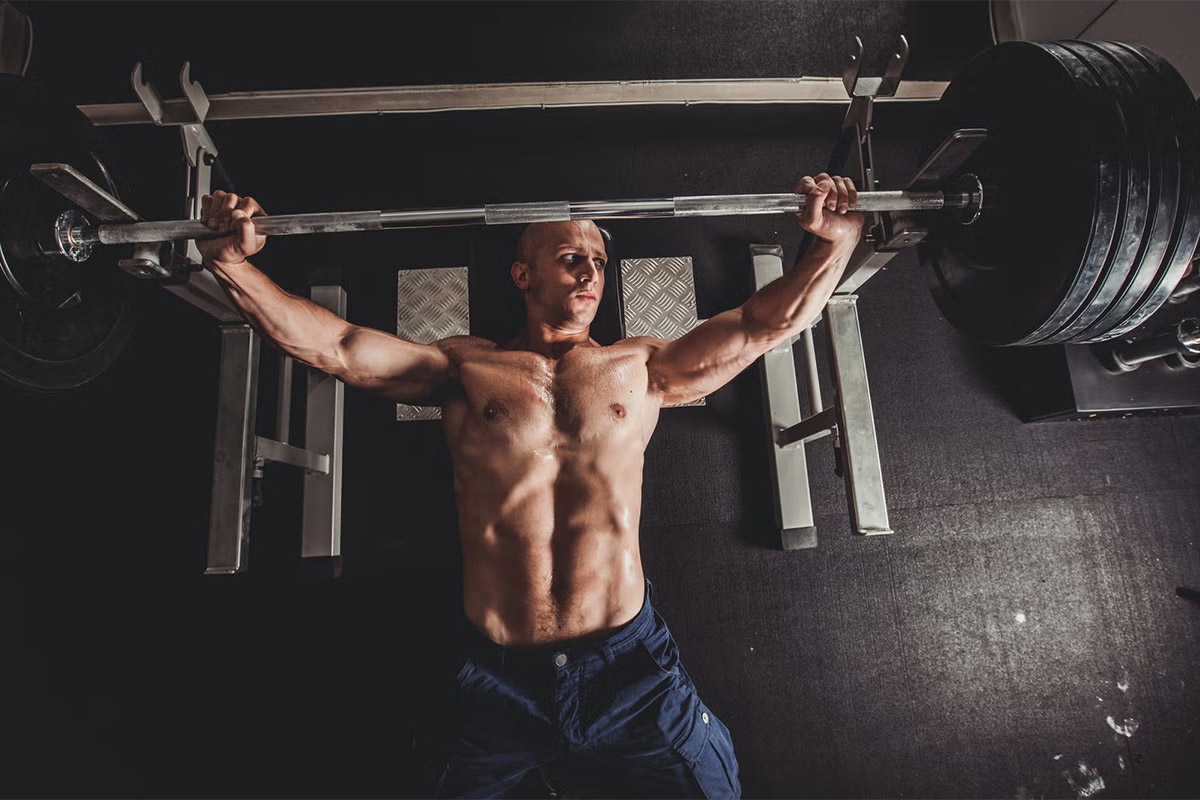 hombre haciendo press de pecho en banco