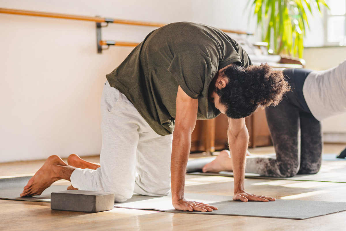 hombre haciendo estiramiento gato-vaca