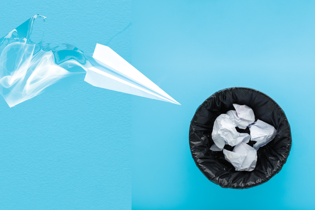 ilustración de avión de papel volando hacia un bote de basura