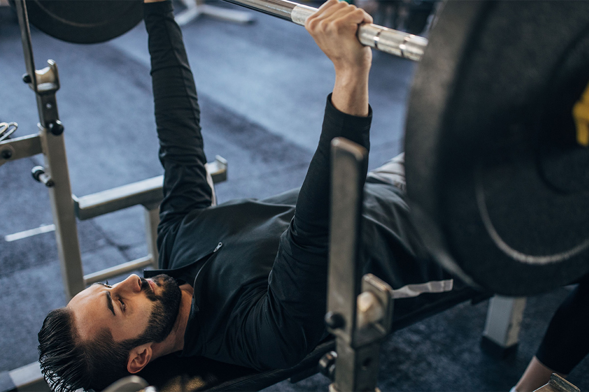 hombre haciendo press de pecho en banco