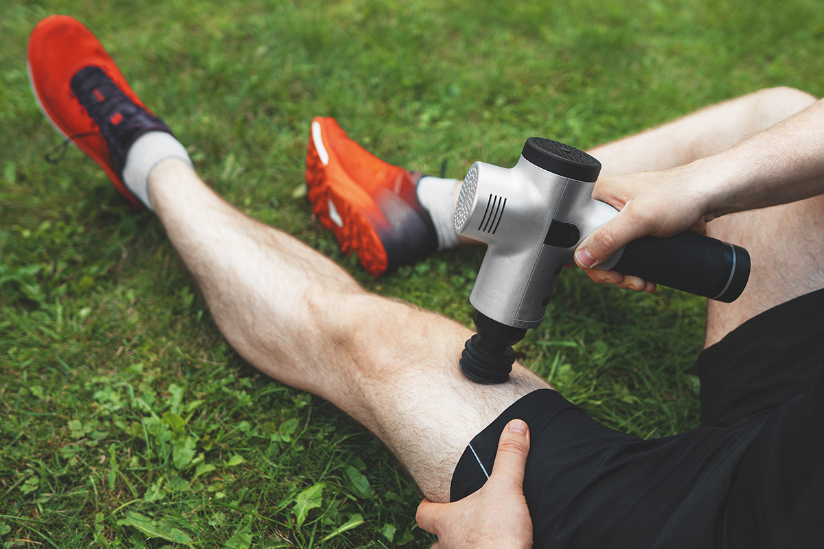 hombre utilizando una pistola de masajes