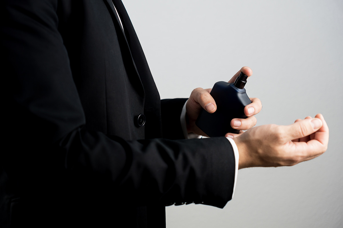 hombre poniéndose perfume