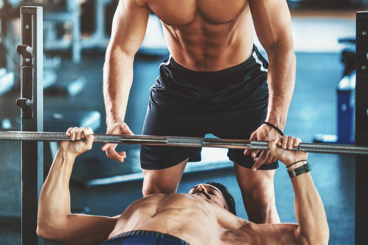 hombre entrenando press de pecho en banco