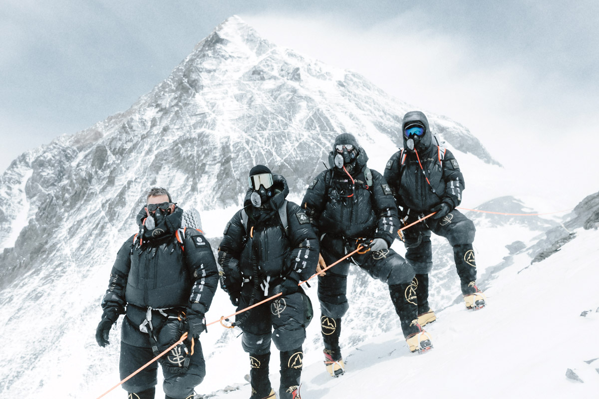 hombres posando frente a la cima del everest