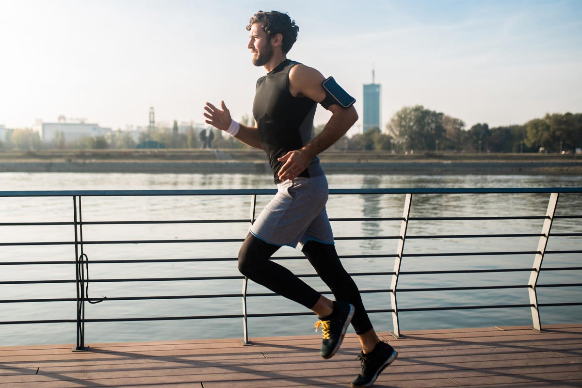 hombre corriendo junto al lago