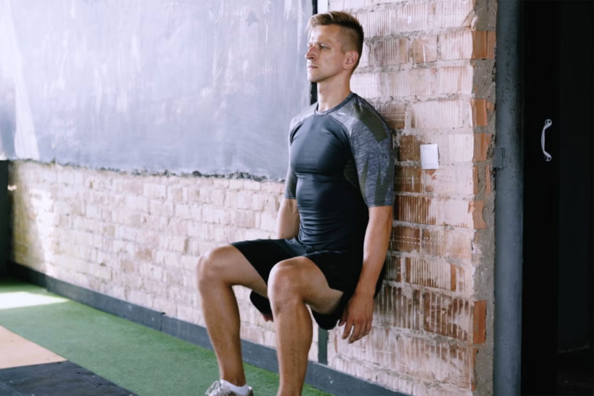 hombre haciendo wall sit