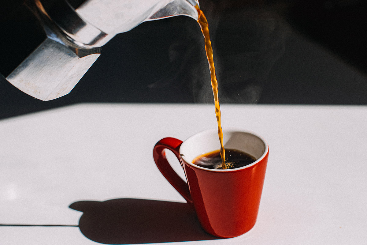hombre sirviendo una taza de café