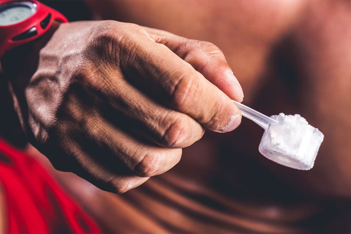 hombre sosteniendo un scoop de creatina