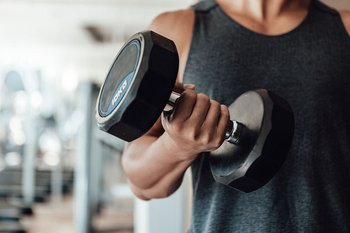 hombre sosteniendo una mancuerna