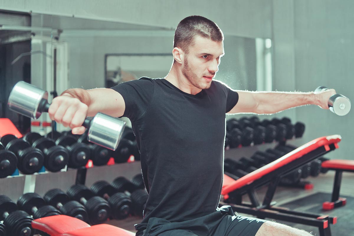 hombre entrenando hombros en el gimnasio
