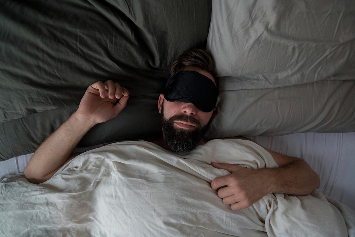 hombre durmiendo con un antifaz para los ojos