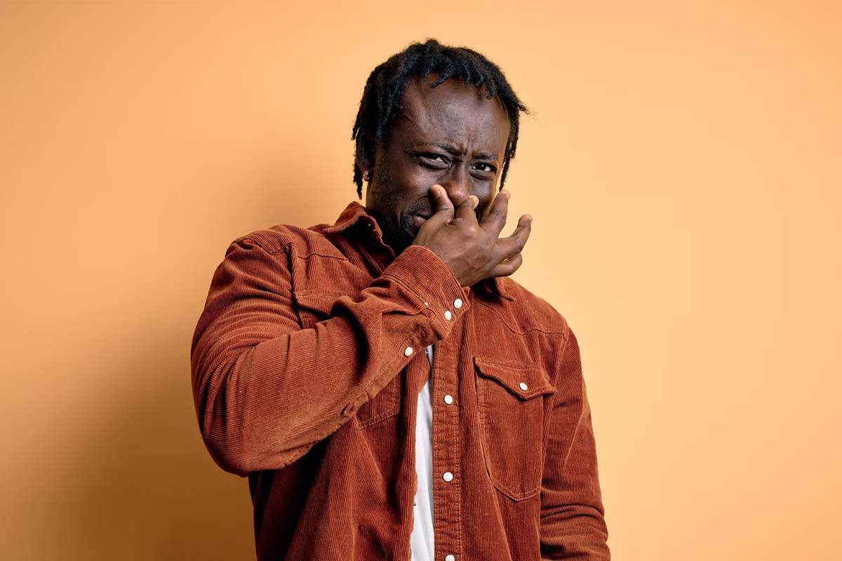 hombre tapándose la nariz